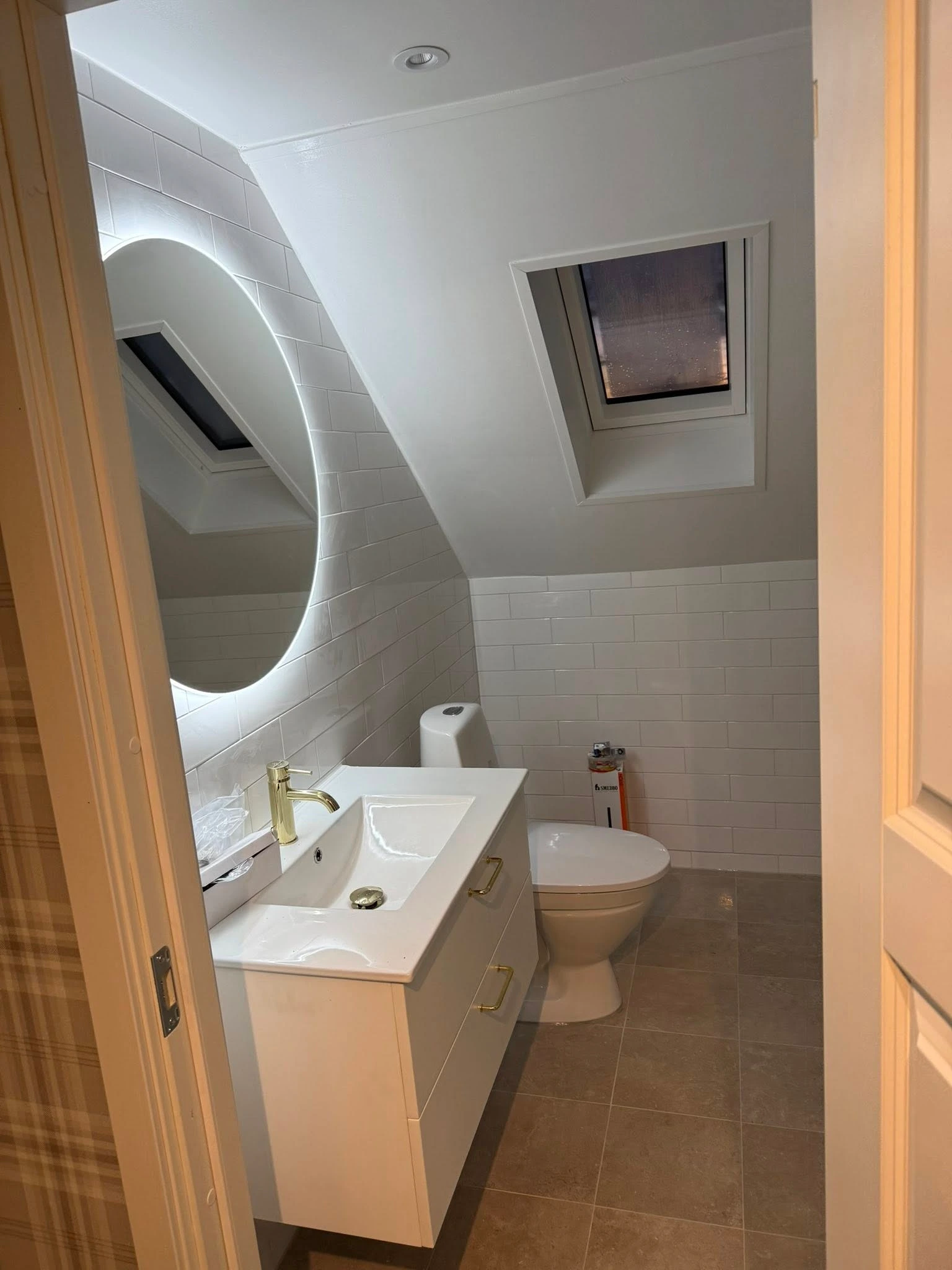 Modernt badrum med glasduschar, träskåp och väggmonterad handfat.